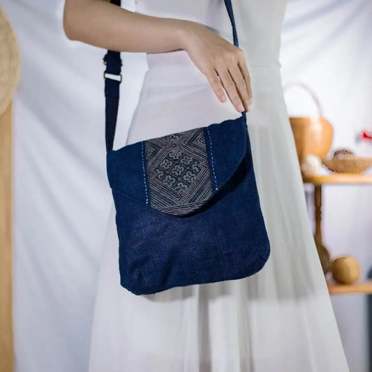 Close-up of indigo hemp crossbody bag with H’mong fabric patch, eco-friendly design.