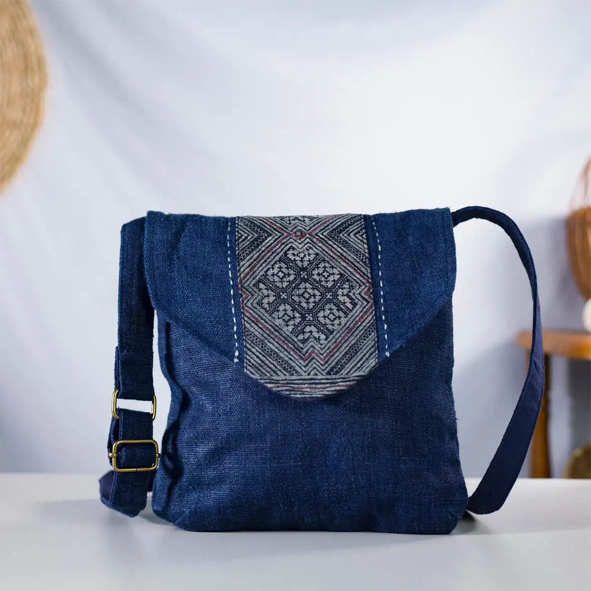 Open view of indigo hemp crossbody bag showing inside and H’mong patch detail, handmade design.