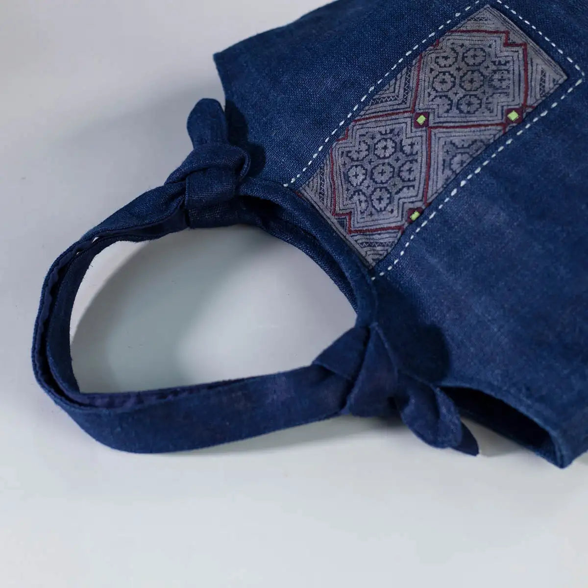 Detail of indigo hemp tote bag with sturdy handles and handmade H’mong patchwork accent.