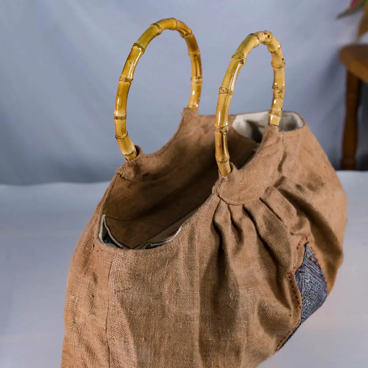 Close-up of bamboo handles on natural hemp bucket bag with H’Mong patch, sustainable handmade design