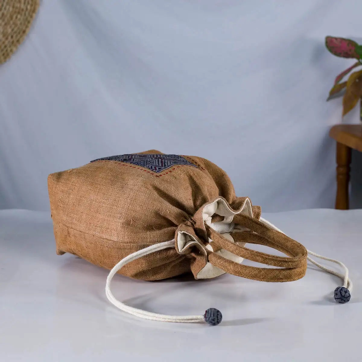 Top view of natural hemp bucket bag with drawstring closure and round fabric handles