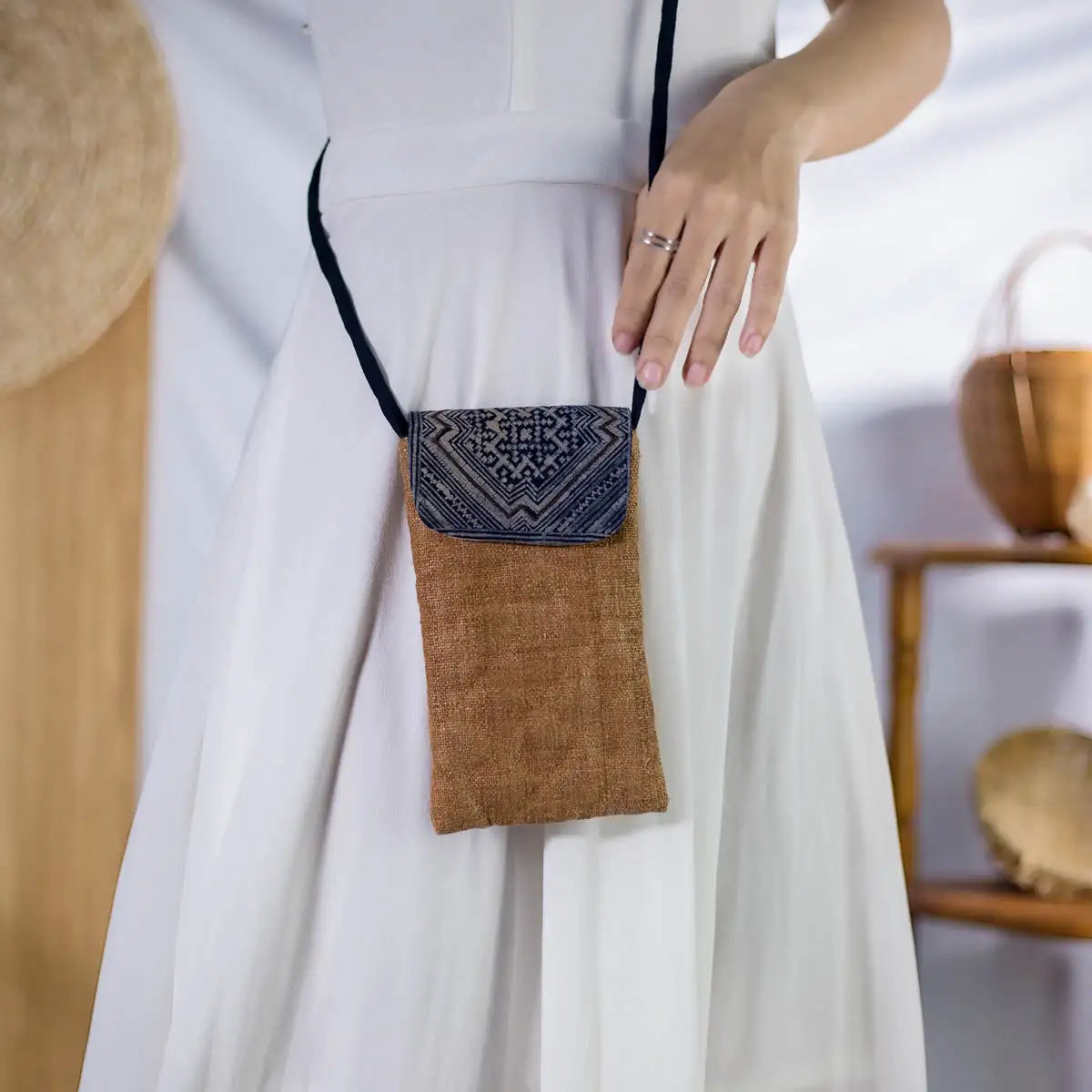 Natural brown hemp phone bag with H’Mong patch, worn crossbody by model, sustainable handmade design.