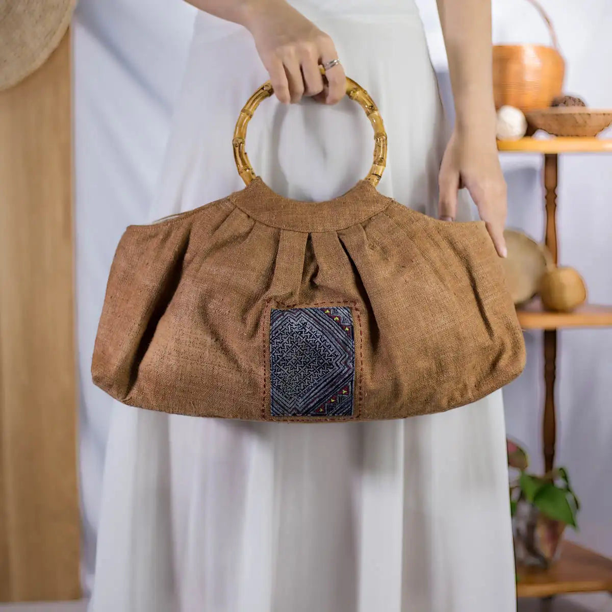 Side view of natural brown hemp bucket bag with bamboo handles and H’Mong patch