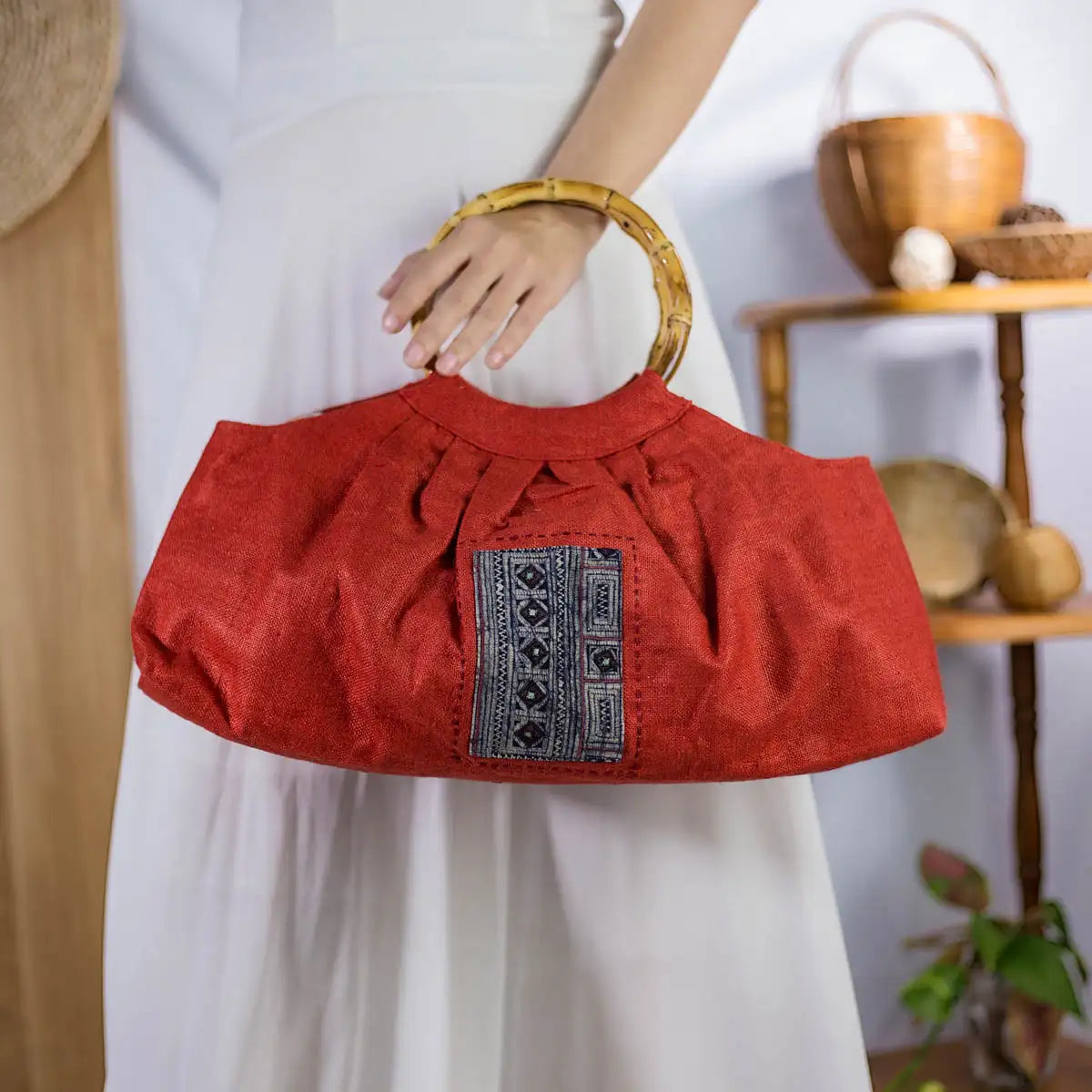 Red hemp handbag with round bamboo handles and authentic H’mong patch, artisan-made design.