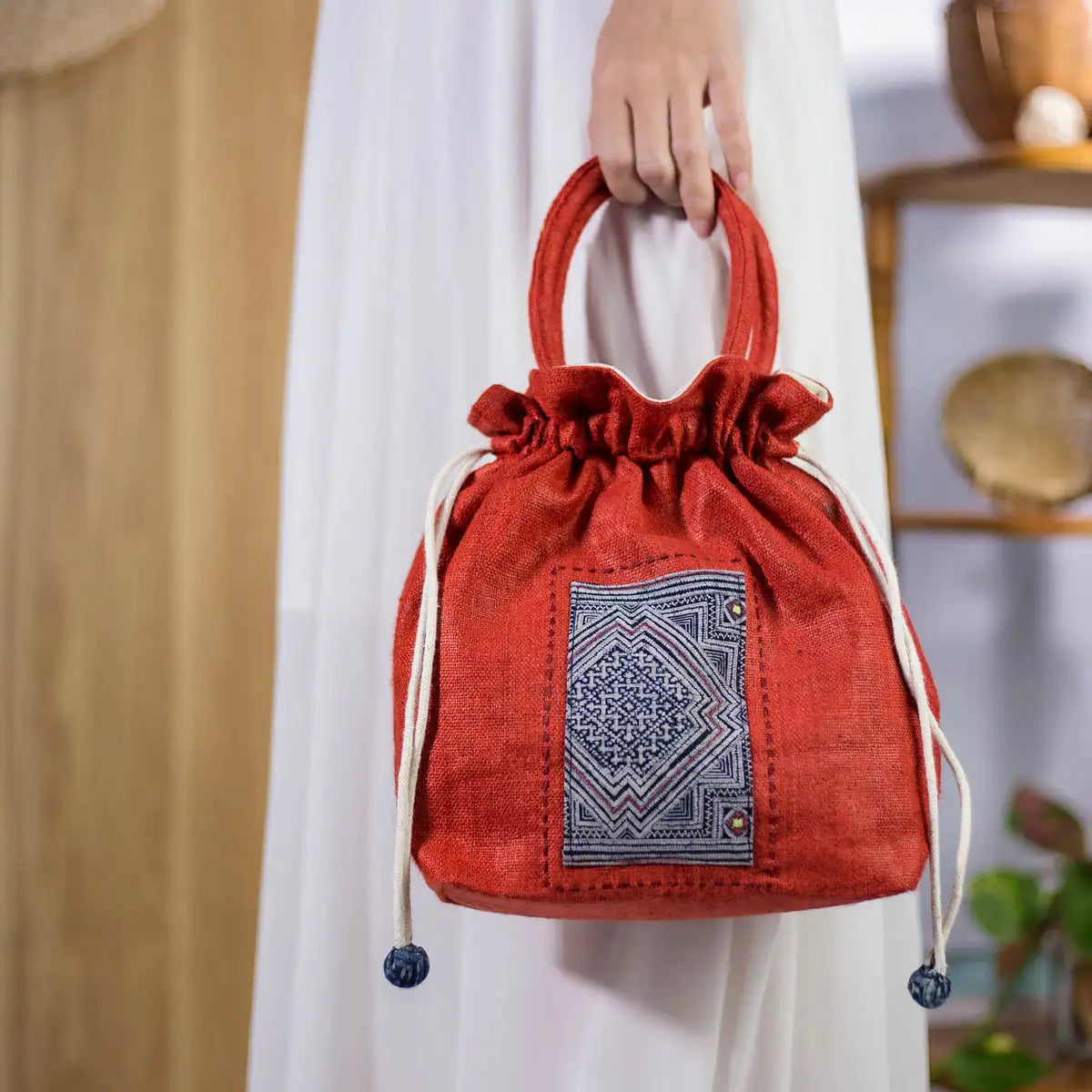 Handcrafted red hemp bucket bag with H’mong fabric patch, sustainable and stylish design.