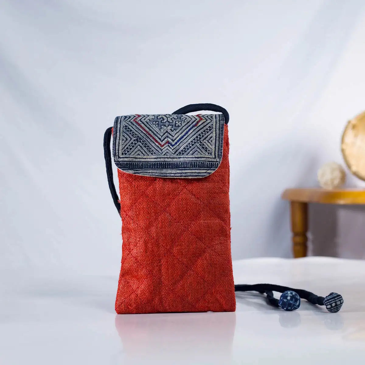 Front view of red hemp mobilväska phone bag with strap and H’mong patch, eco-friendly design.