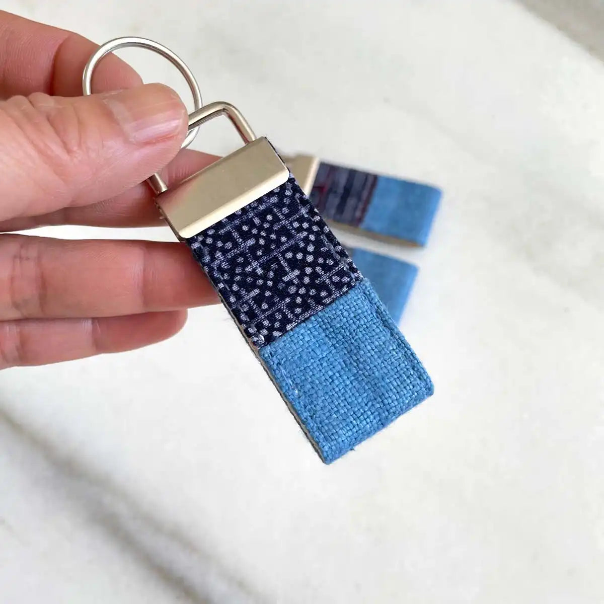 Vindigo keychain blue embroidered close detail in hand