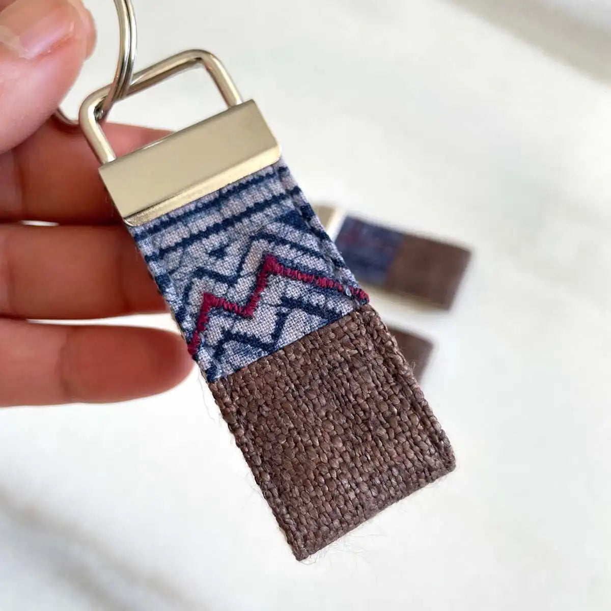 Vindigo keychain brown embroidered close detail in hand