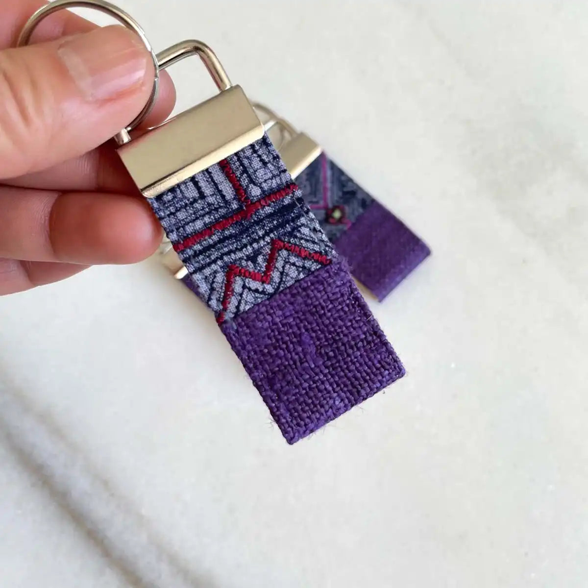 Vindigo keychain purple embroidered close detail in hand