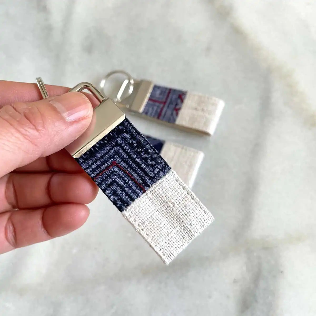 Vindigo keychain white embroidered close detail in hand