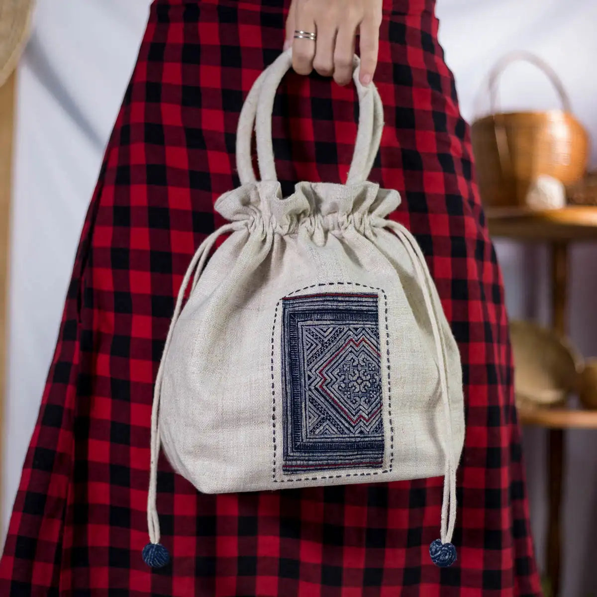 Model holding white hemp bucket bag with H’Mong batik patch
