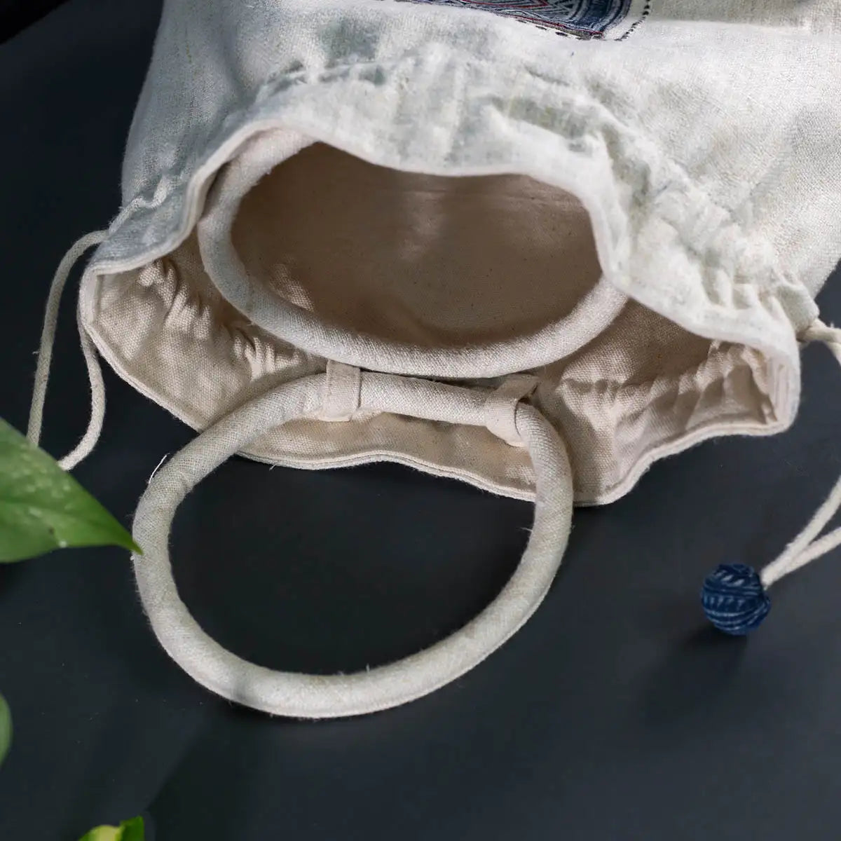Inside view of white hemp bucket bag with batik patch and drawstring