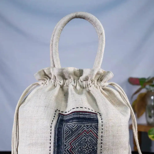 Open white hemp bucket bag showing batik patch and drawstring