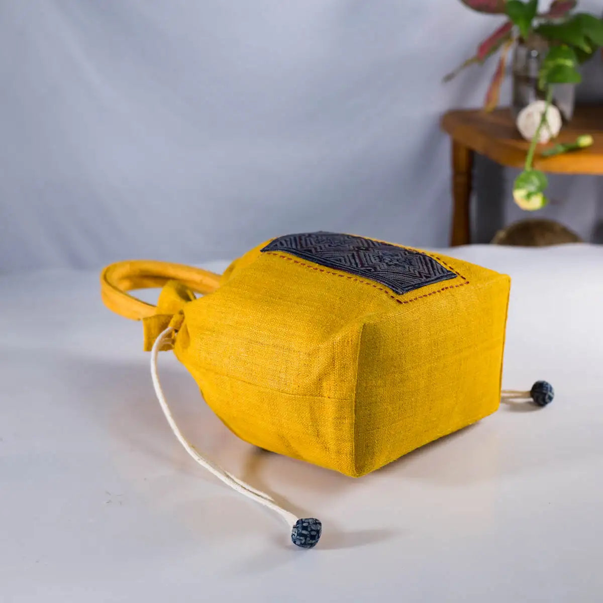 Bottom view of yellow hemp bucket bag with embroidery and drawstring by Vindigo