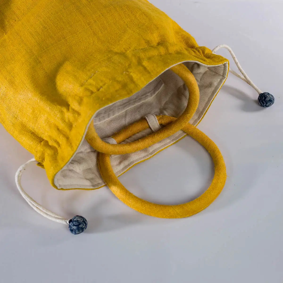 Close-up of yellow hemp drawstring bucket bag handle and drawstring by Vindigo