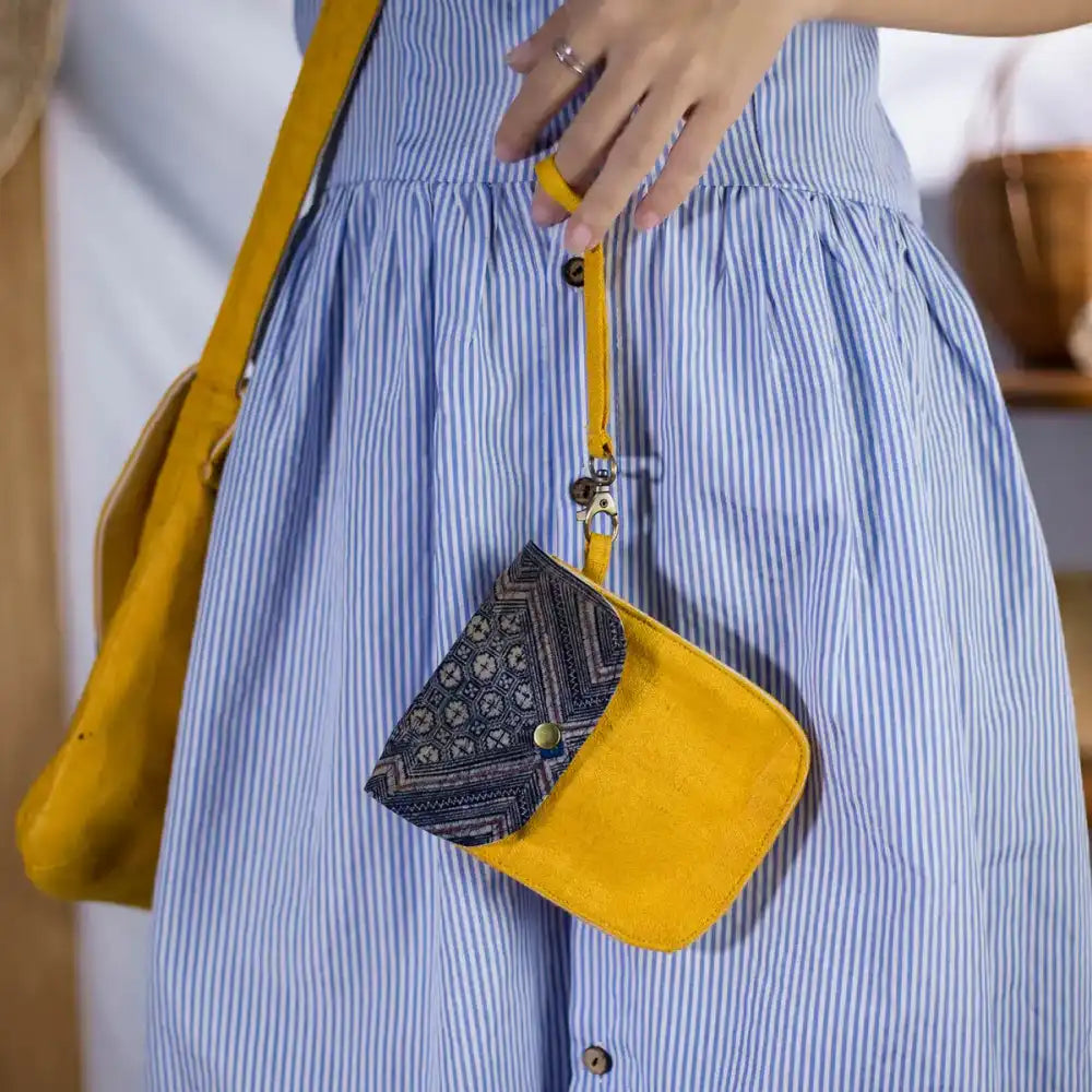 Model carrying yellow hemp flip phone belt bag with H’Mong patch, eco-friendly handmade.