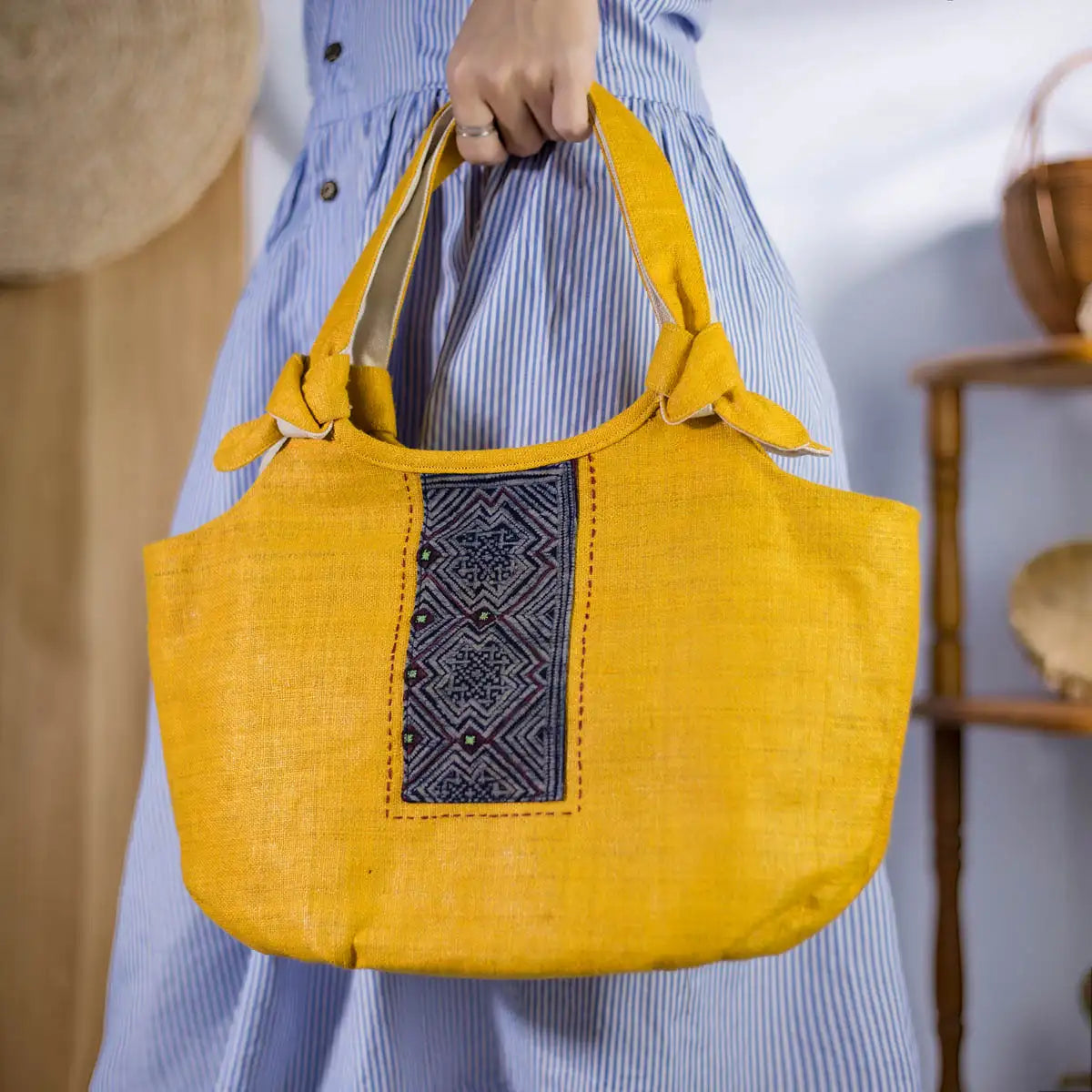 Yellow hemp handbag with H’Mong patch carried by model – Vindigo artisan bag