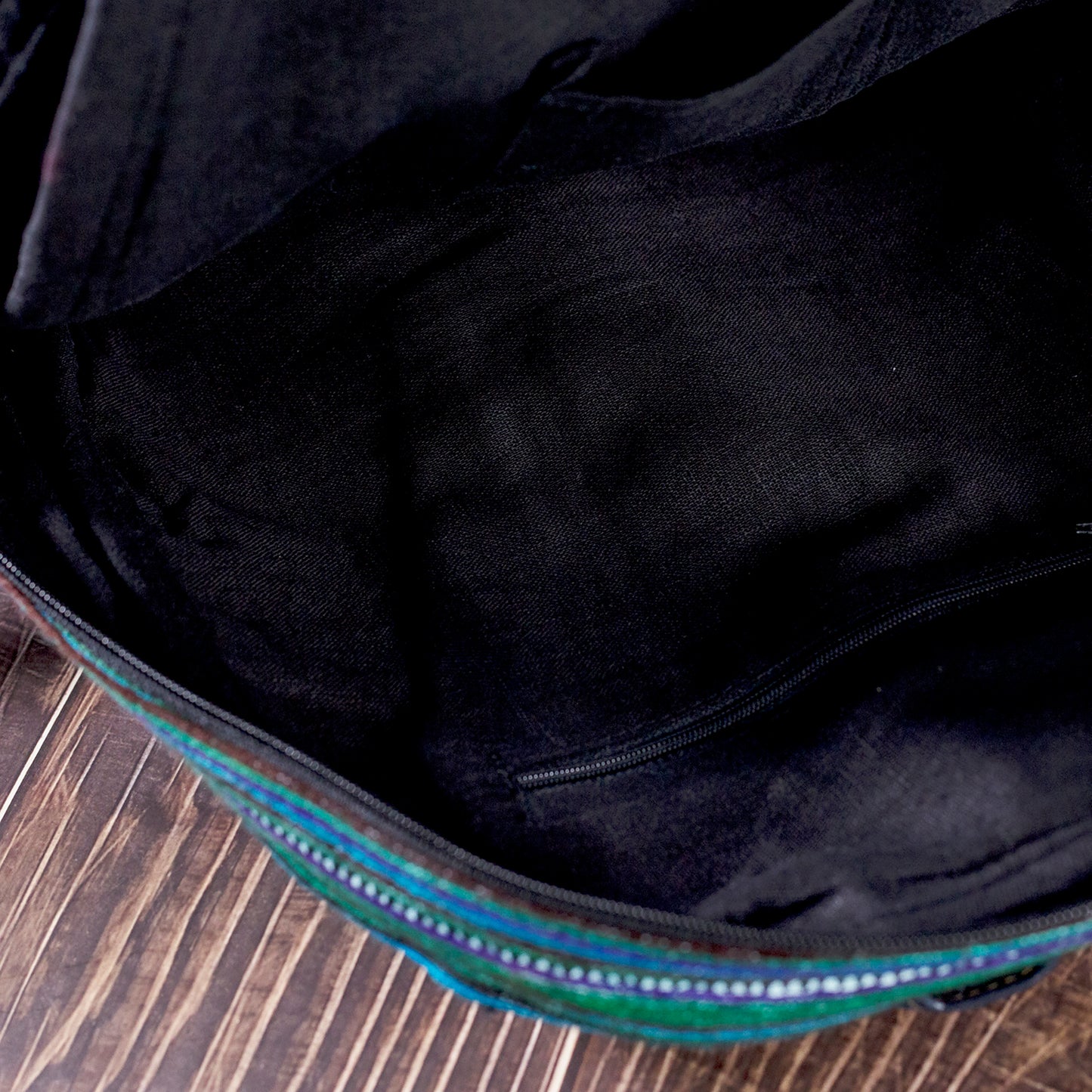 Stor ryggsäck, rund ficka framtill, blått handbroderityg, svart konstläderkant